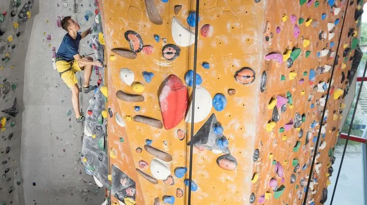 Eine Sportlerin klettert am Kletterturm hoch | © DAV / Jens Klatt